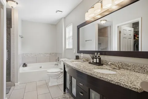 a bathroom with a granite countertop sink a toilet and bathtub