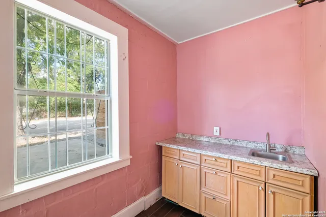 a bathroom with a granite countertop sink and a large mirror next to a window