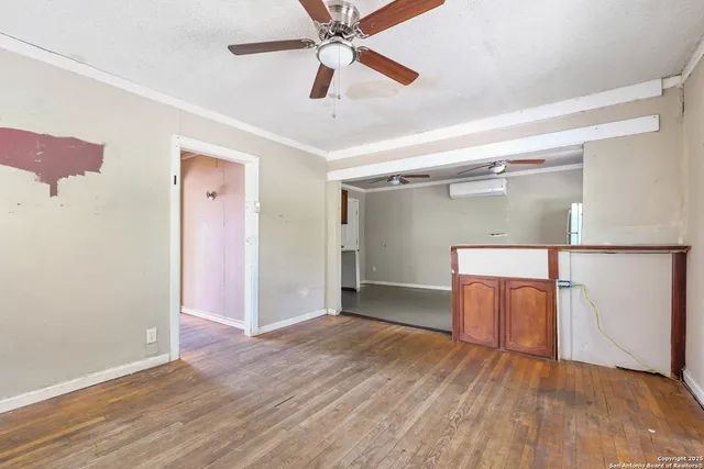 an empty room with wooden floor closet and windows