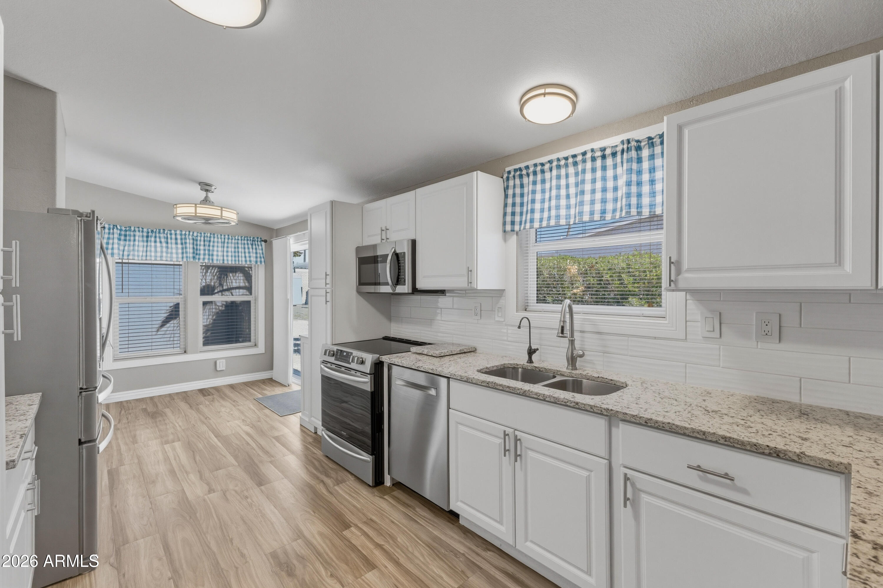 2000 South Apache Road, Unit 371 Buckeye, AZ 85326 - Photo 12 of 38 a kitchen with stainless steel appliances granite countertop a sink cabinets and wooden floor