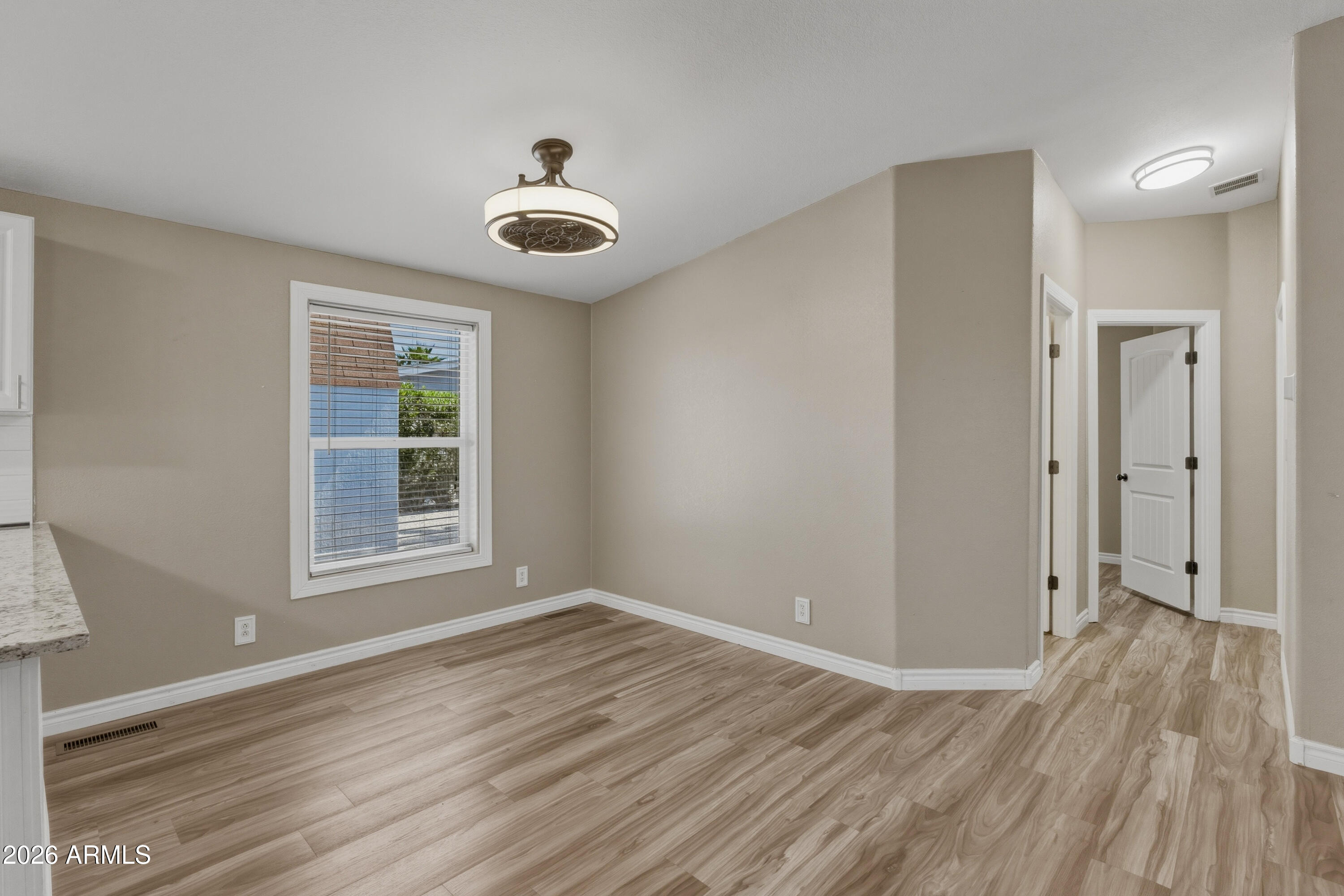 2000 South Apache Road, Unit 371 Buckeye, AZ 85326 - Photo 14 of 38 an empty room with wooden floor and windows