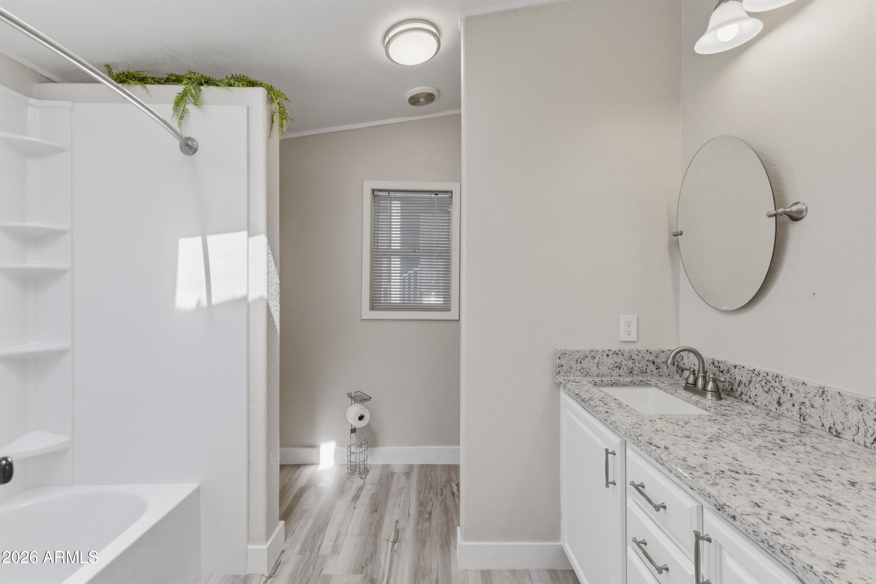2000 South Apache Road, Unit 371 Buckeye, AZ 85326 - Photo 20 of 38 a bathroom with a granite countertop sink mirror and a bathtub