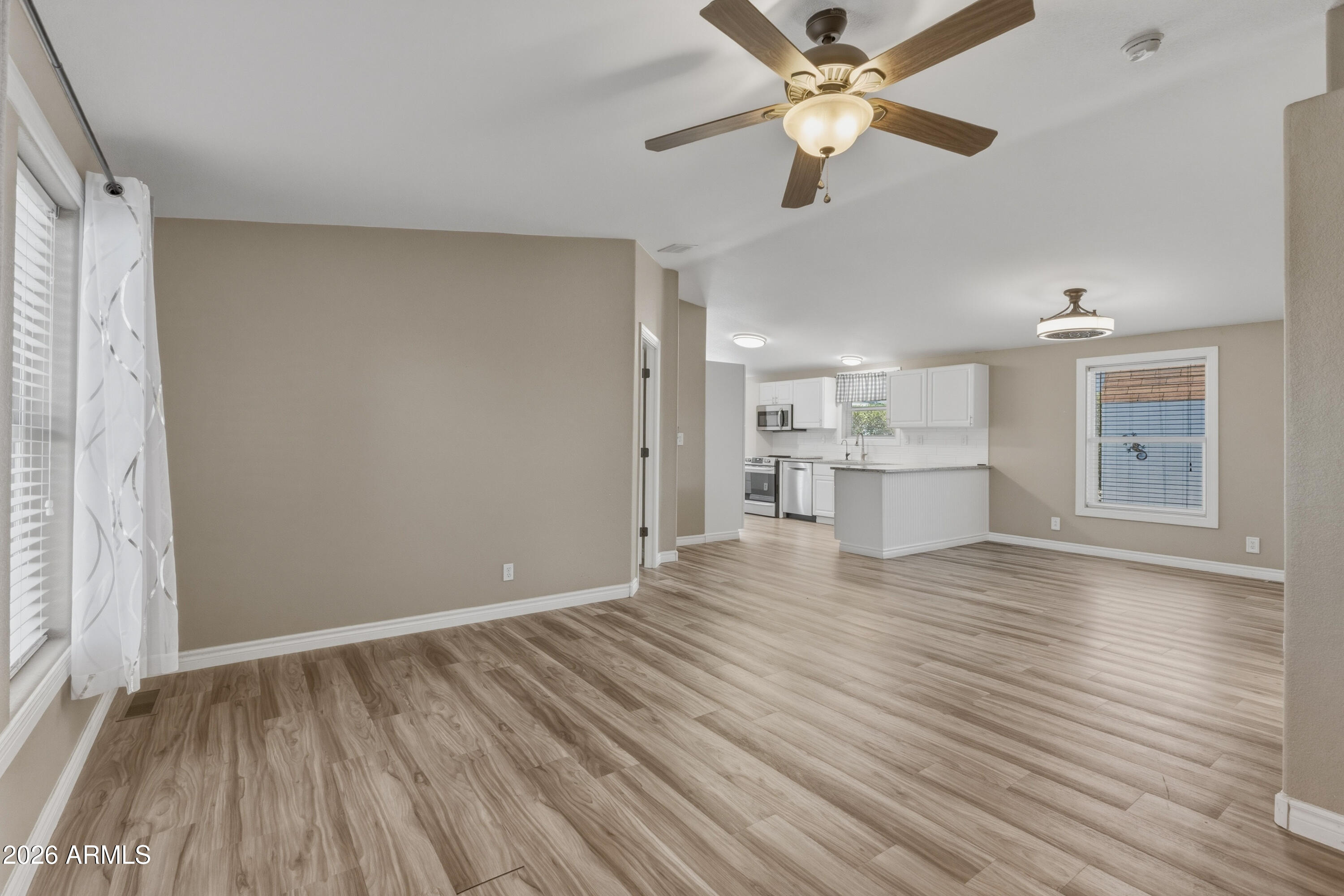 2000 South Apache Road, Unit 371 Buckeye, AZ 85326 - Photo 4 of 38 a view of a room with wooden floor and a kitchen