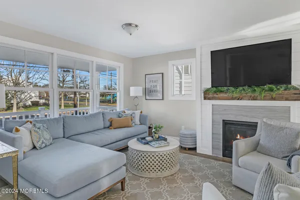 a living room with furniture a flat screen tv and a fireplace
