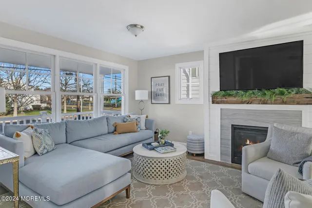 a living room with furniture a flat screen tv and a fireplace