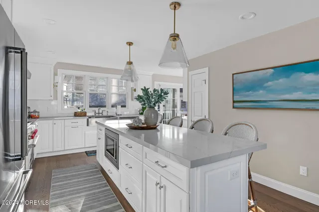 a kitchen with white cabinets and sink