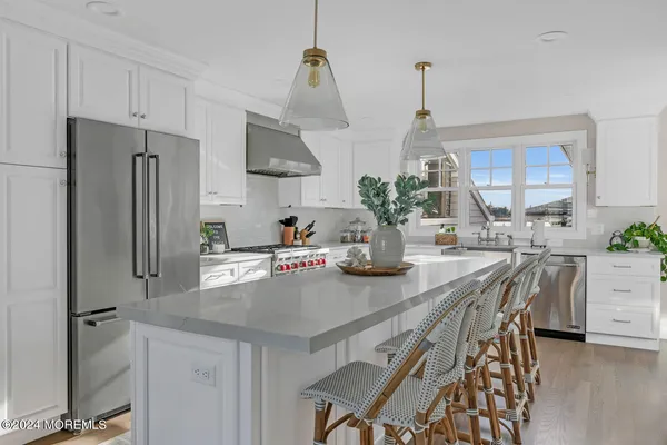 a kitchen with stainless steel appliances a table chairs and refrigerator