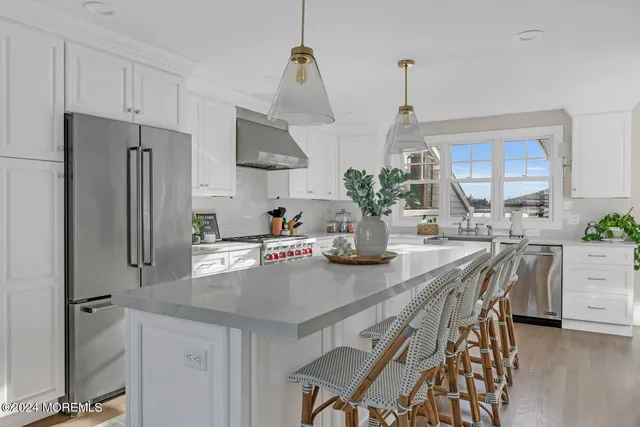 a kitchen with stainless steel appliances a table chairs and refrigerator