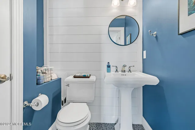 a bathroom with a toilet sink and mirror