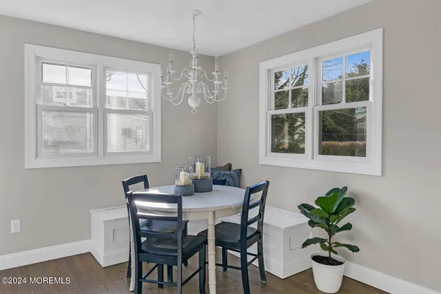 a dining room with furniture potted plants and wooden floor