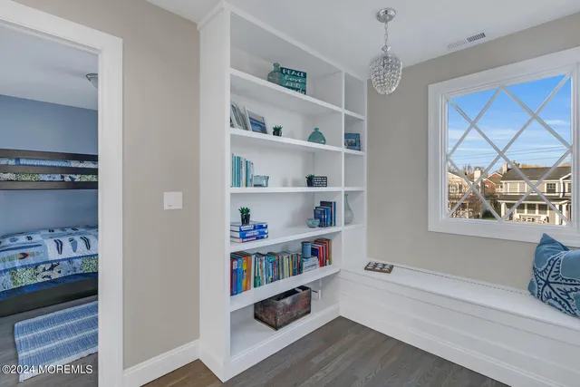 a room with a book shelf and a window