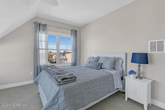 a bed sitting in a bedroom next to a window