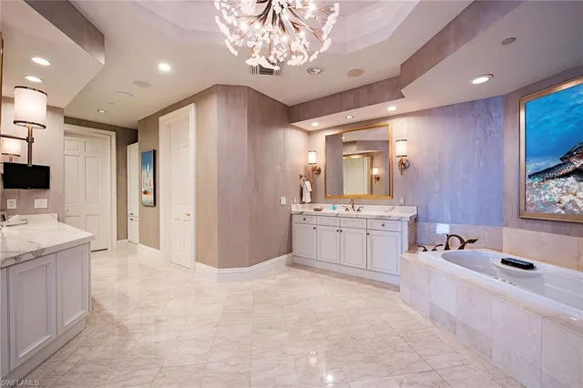 a large white kitchen with a large window a sink and a stove top oven