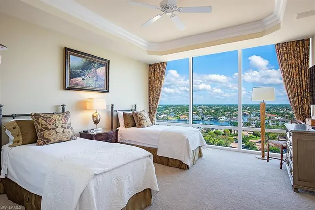 a bedroom with two beds and a large window with outer view