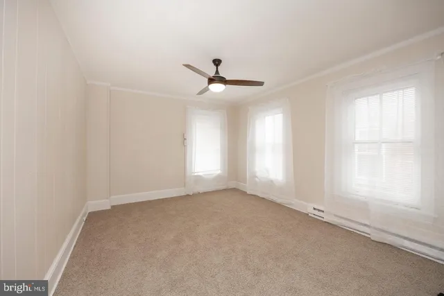 an empty room with a window and a ceiling fan
