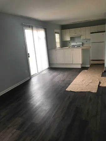 a view of a kitchen with wooden floor and cabinets