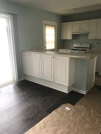 a kitchen with granite countertop a sink a window and cabinets