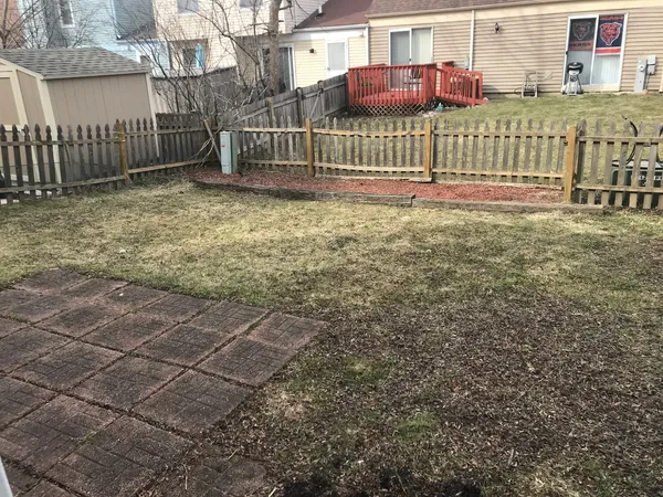 a view of a house with a small yard and wooden fence