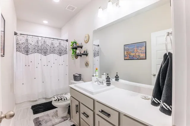 a bathroom with a sink a toilet and a mirror