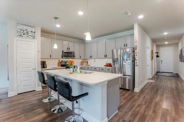 a kitchen with a sink a refrigerator and wooden floor