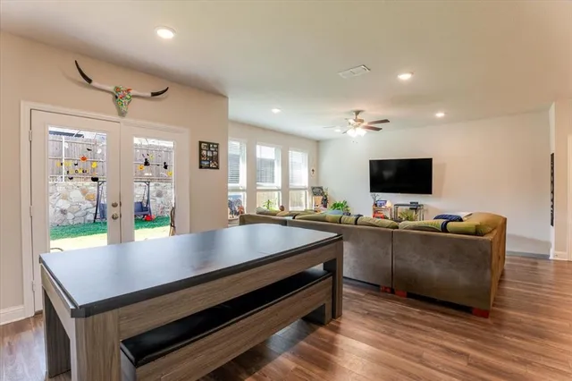 a living room with furniture a flat screen tv and kitchen view