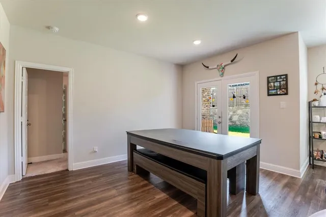 a room with pool table and wooden floor