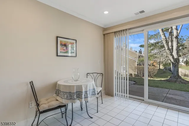 a dining room with furniture and a floor to ceiling window