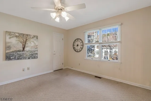 an empty room with a window and a ceiling fan