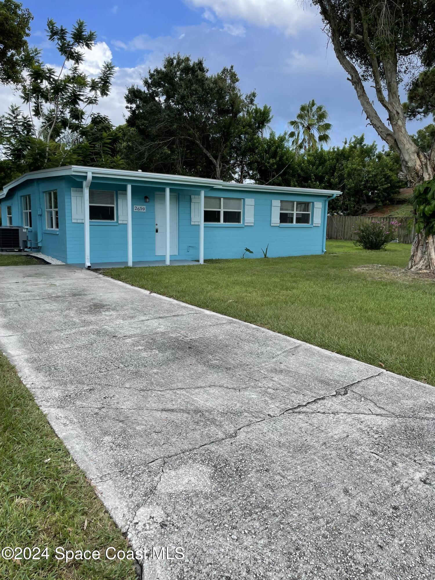 2659 Burns Avenue Melbourne, FL 32935 - Photo 1 of 10 a front view of a house with a yard and garage