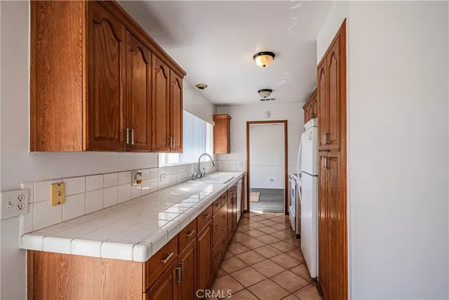 a kitchen with granite countertop a sink and a refrigerator