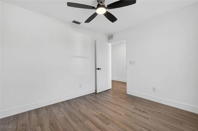 a view of empty room with wooden floor