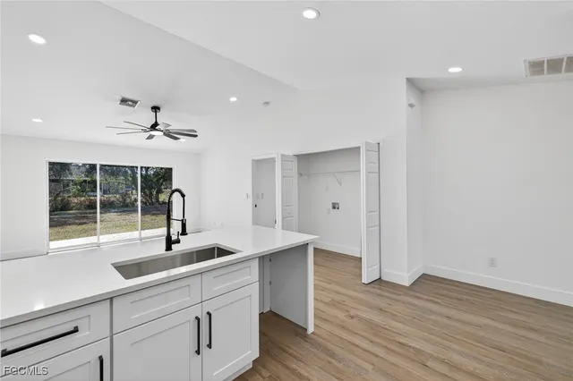 a kitchen with stainless steel appliances granite countertop a sink a stove and a wooden floors