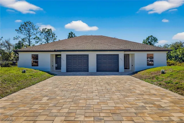 a front view of house with a garden