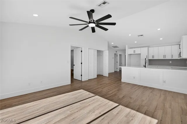 a living room with wooden floor and a ceiling fan