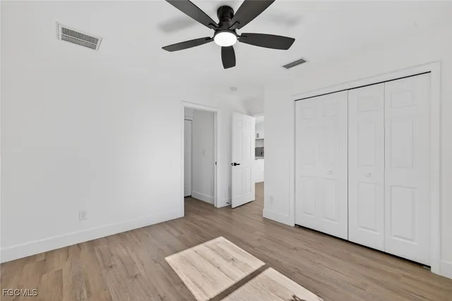 an empty room with wooden floor a ceiling fan and closet