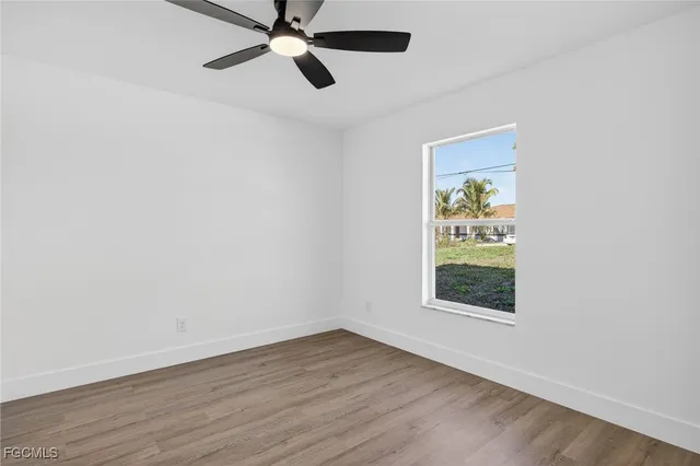 an empty room with a window and a ceiling fan