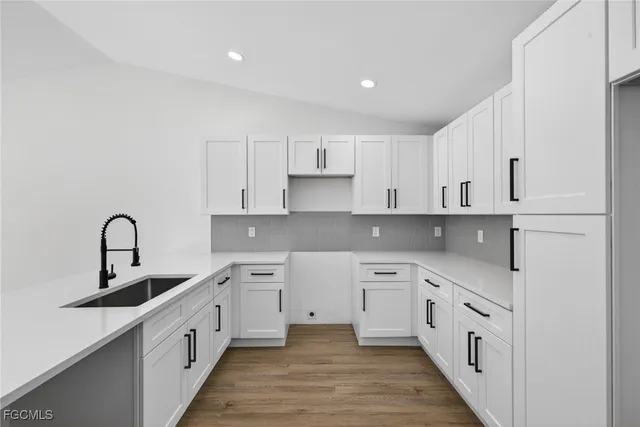 a kitchen with white cabinets appliances and sink