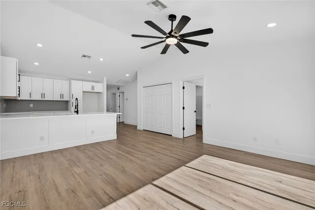 a view of a kitchen with a sink and wooden floor