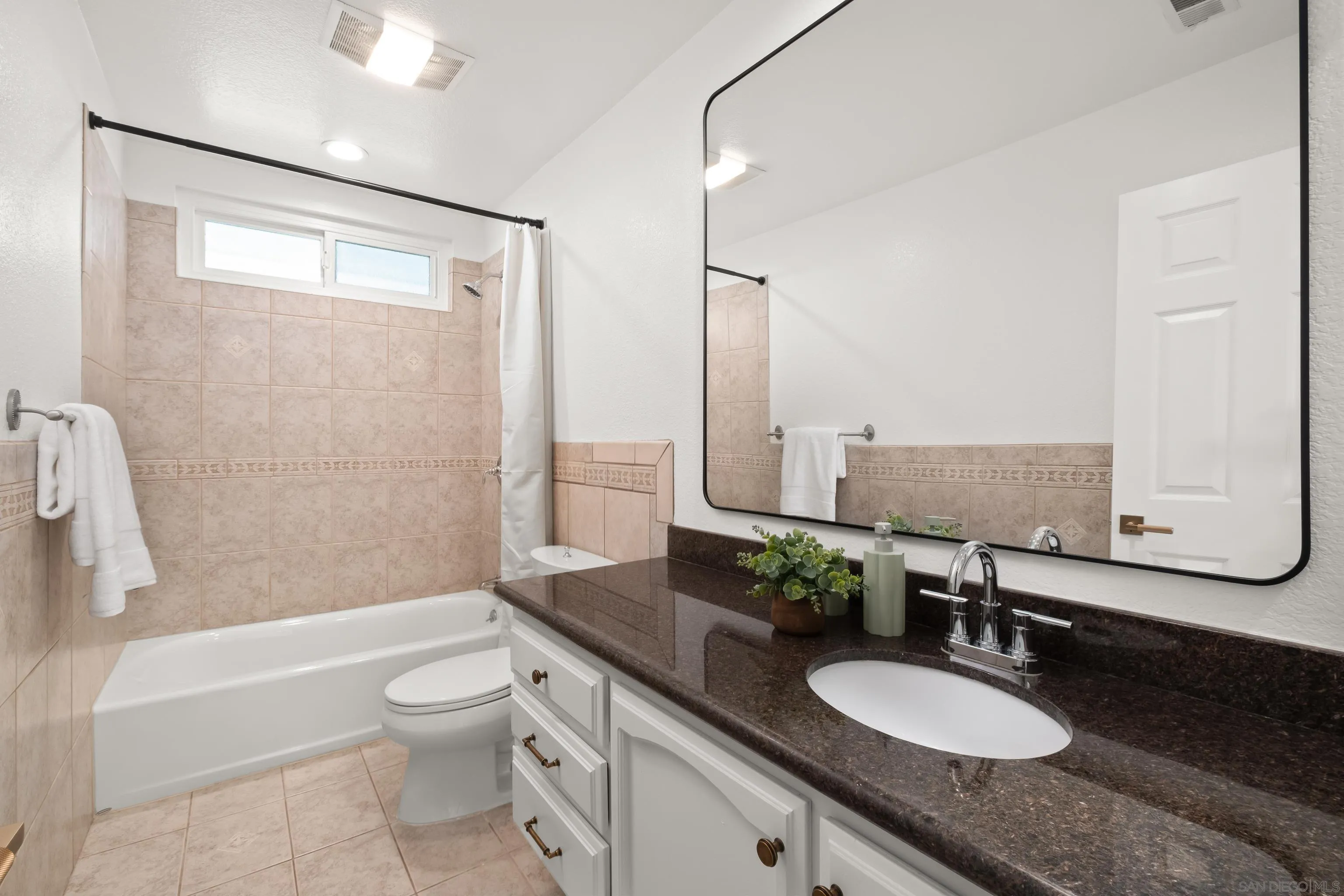 11478 Madera Rosa Way San Diego, CA 92124 - Photo 23 of 54 a bathroom with a granite countertop sink and a mirror