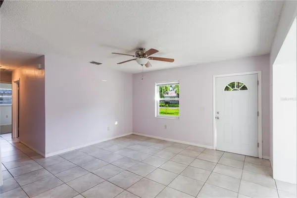 an empty room with windows and a ceiling fan