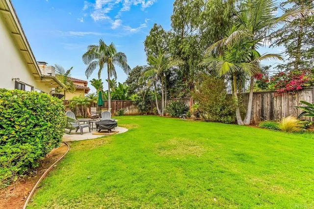 a view of a backyard with sitting area and garden