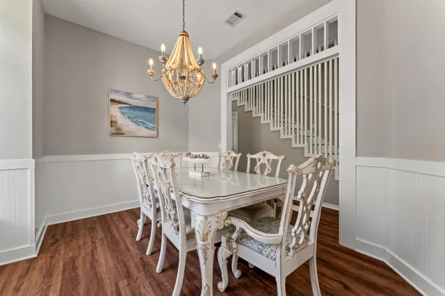 a kitchen with stainless steel appliances a dining table chairs and wooden floor