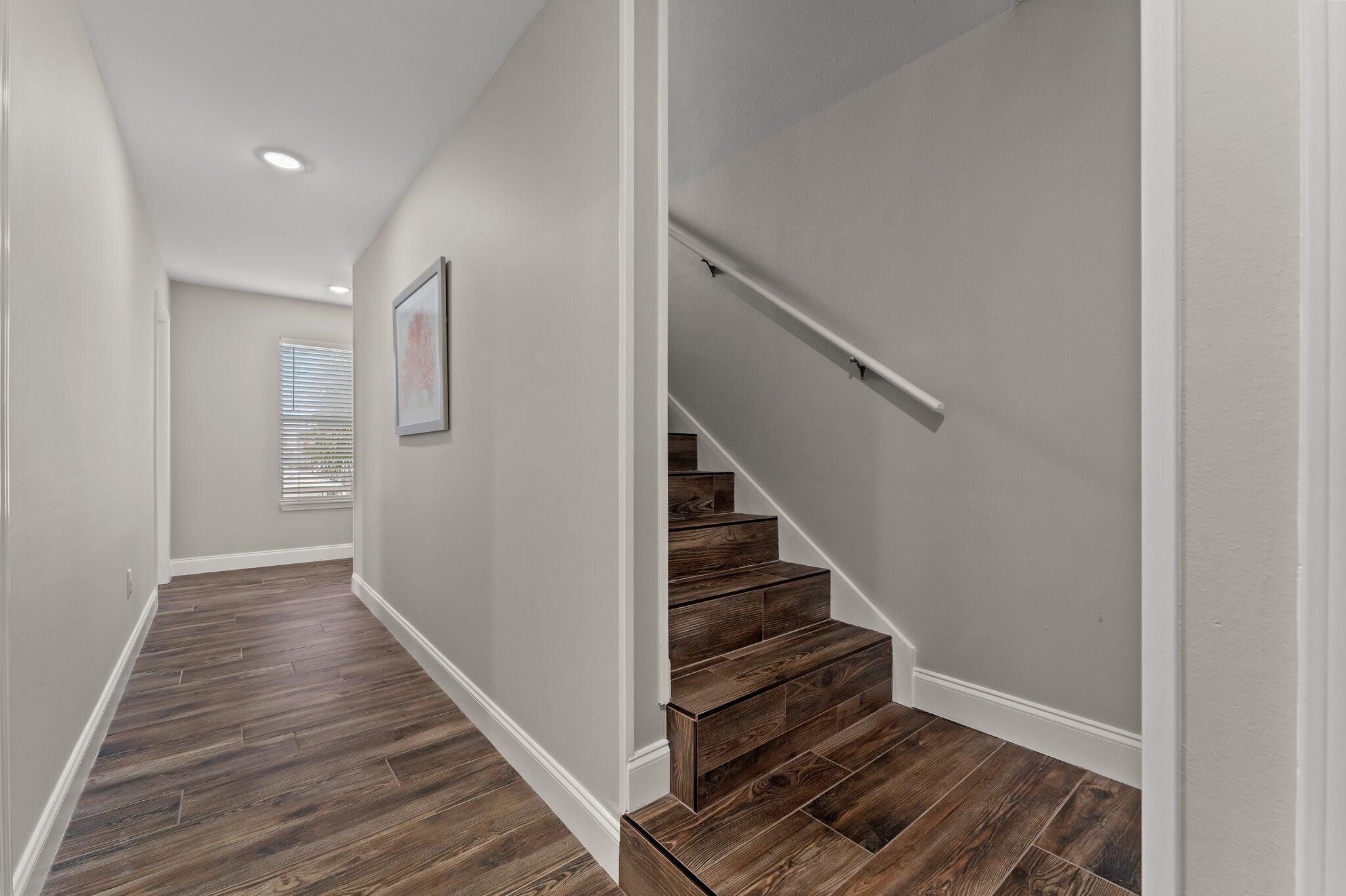 4455 Ocean View Drive Destin, FL 32541 - Photo 42 of 56 a view of a hallway with wooden floor and staircase