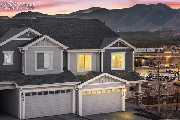 a front view of a house with a yard and balcony