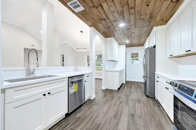 a kitchen with cabinets a sink and wooden floor