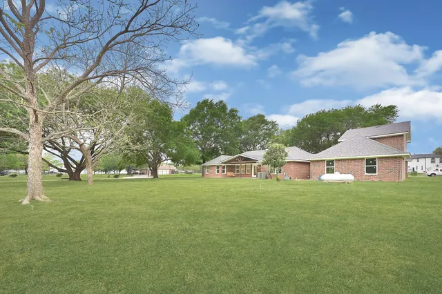 a front view of a house with a garden and trees