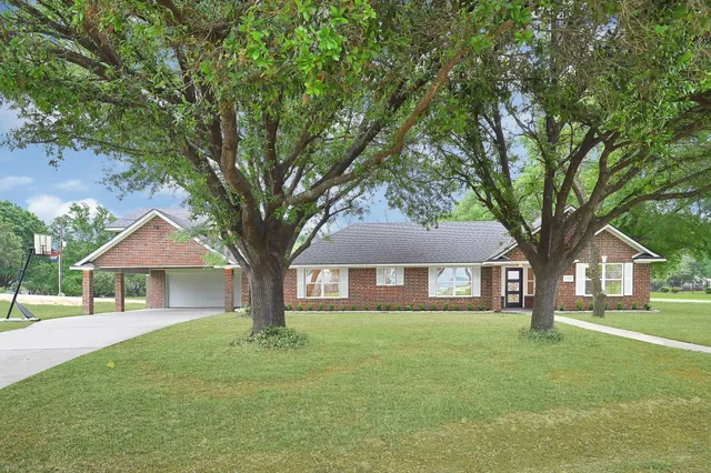 an aerial view of a house with a yard and lake view