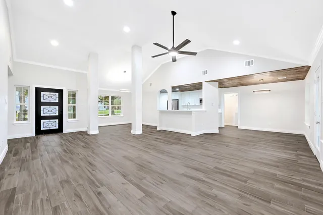 a view of empty room with wooden floor and ceiling fan