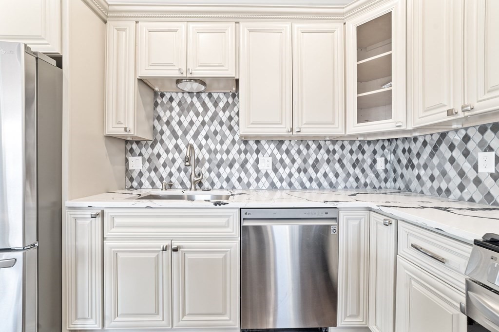 44 Bowdoin Street, Unit 2 Boston, MA 02124 - Photo 15 of 33 a kitchen with granite countertop white cabinets and a sink
