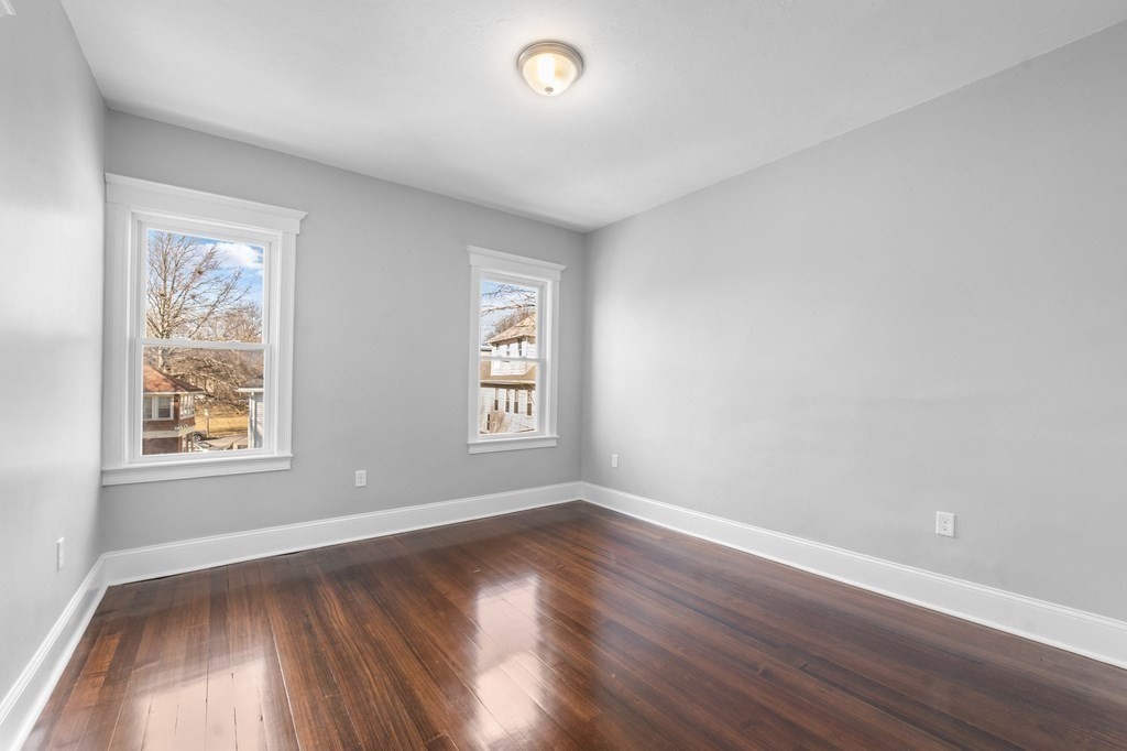 44 Bowdoin Street, Unit 2 Boston, MA 02124 - Photo 22 of 33 an empty room with wooden floor and windows